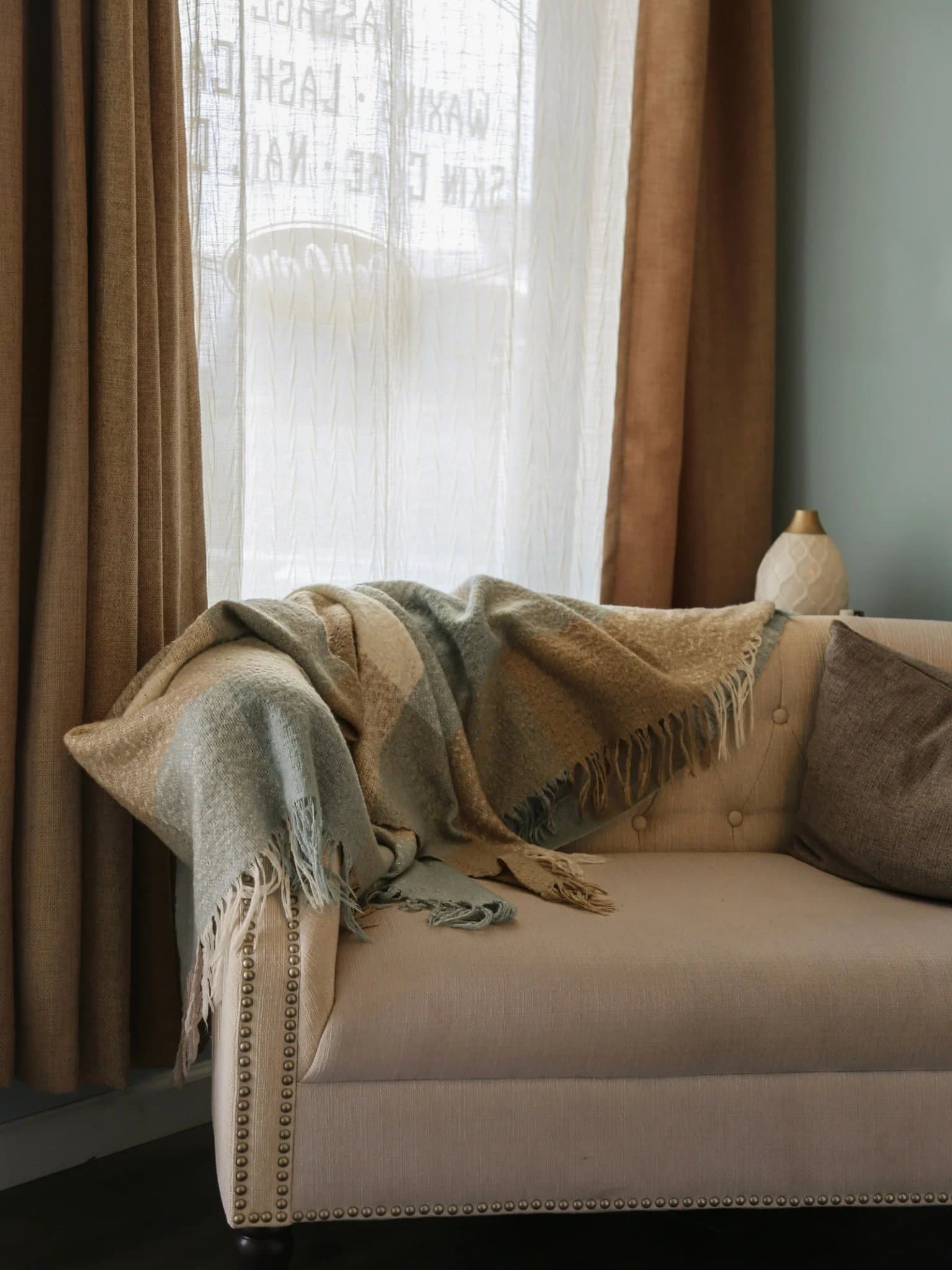Spa interior with linen-draped loveseat near sunlit window